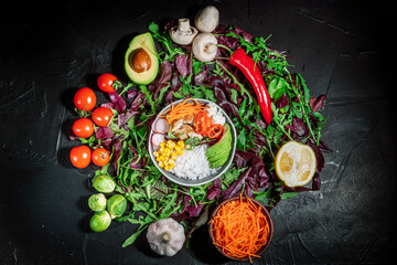 Green vegan salad from green leaves mix, rice and vegetable power bowl. Healthy balanced food concept. Buddha bowl. Diet food. On a dark background, top view