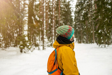 Fototapeta na wymiar Rear view of man enjoying a walk through the woodland during winter 