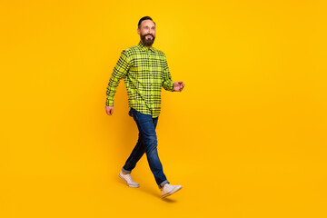 Fototapeta na wymiar Full body profile side photo of cheerful handsome man happy positive smile go walk step isolated over yellow color background