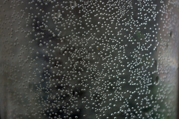 Dark unusual water with small white bubbles across the background. 