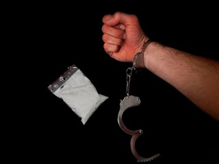 Handcuffed man and cocaine drug powder pile, arrested drug dealer