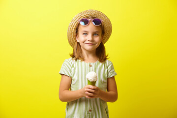 Little girl in summer clothes holding beautiful ice cream on yellow isolated.