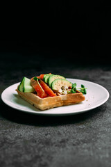 Belgian waffles with salmon, avocado and cream cheese on a white plate. Healthy breakfast