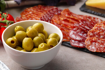 Close up of bowl with green olives on table