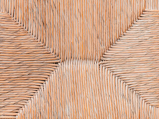 Geometric pattern of seat of a wicker chair.  Furniture in a cafe, a restaurant. Beige color. Part of interior