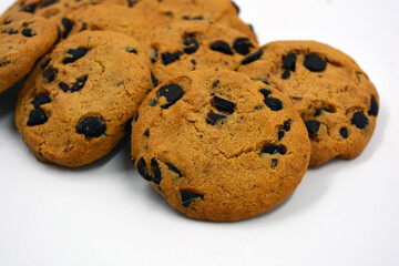 A large delicious sweet cookie with chocolate pieces arranged on a white background. 