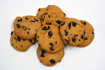 A large delicious sweet cookie with chocolate pieces arranged on a white background. 