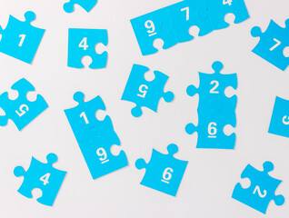 Blue puzzle pieces with numbers on a white background, logo of autism. April 2, Autism World Awareness day. Top view