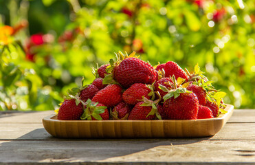 Fresh organic strawberries on a wooden plate. .Red ripe berries, fresh juicy strawberries. Healthy or diet food concept.