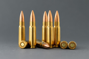 Bullets on gray background. Cartridges 7.62 caliber for Kalashnikov assault rifle closeup - obrazy, fototapety, plakaty