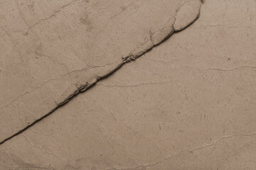 The texture of old stained, faded cardboard. Cardboard sheet with torn, frayed edges.