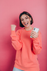 Excited young woman amazed by unbelievable shopping mobile app sale message looking at smartphone, girl winner holding cell phone screaming with joy