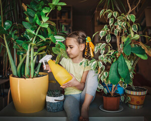 Cute girl helping to care for home plants on the window, plant parents concept, home gardening, green environment at home