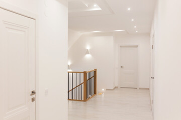 Modern house interior with white walls and doors and wooden staircase