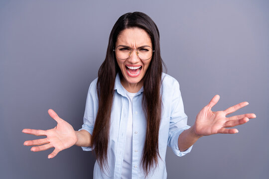 Photo of aggressive angry mature woman wear formal shirt spectacles rising arms isolated grey color background