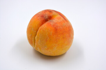 Tasty and useful fresh fruits, ripe red and orange peaches with a terry white skurt are located on a white background. 