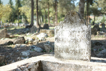 Old Muslim tombstone in Turkish cemetery. Weathered headstone on an ancient graveyard.