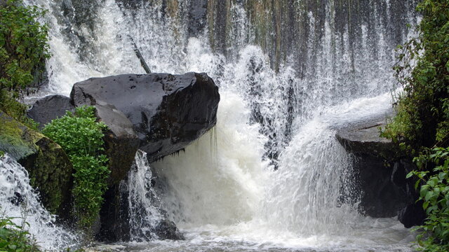 Water splashing down into a pool at the base of Peguche Falls, outside of Otavalo, Ecuador