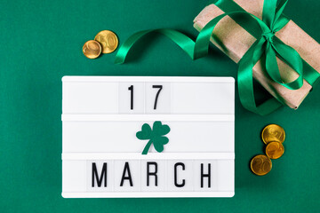 St. Patrick's Day. Good luck symbols. Gold coins and clover shamrock on green background.