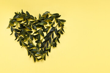 heart lined with green leaves on a yellow background