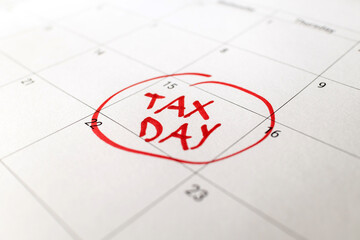 Fototapeta premium Tax day marked on April 15 calendar with red marker. Deadline for 1040 form return.