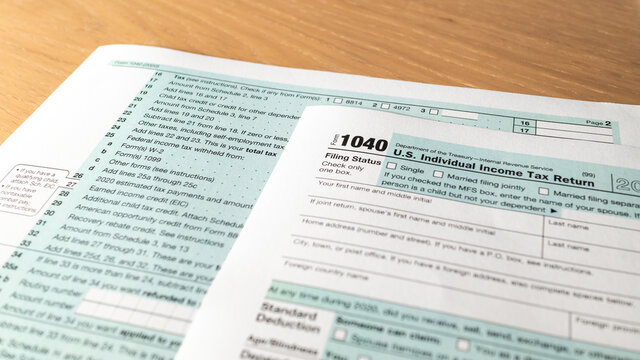 Tax day. 1040 form and calculator on table ready to be filled and returned.
