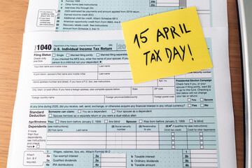 Fototapeta premium Tax day. 1040 form and calculator on table ready to be filled and returned.