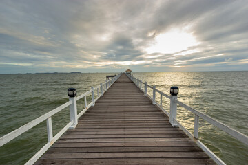 Fototapeta premium wood bridge in evening at Casaluna village in Thailand , wooden pier on the beach ,Wooded bridge in the port between sunrise.