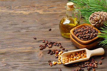 Cedar cones, nuts and cedar nut oil isolated on a wooden table