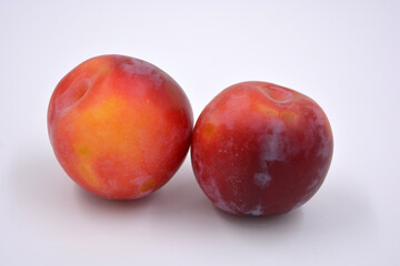 Fototapeta na wymiar Delicious useful fruits, red, cherry ripe plums located on a white background. 