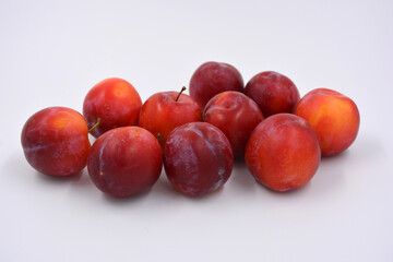 Delicious useful fruits, red, cherry ripe plums located on a white background. 