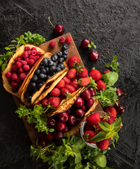 Berries wrapped in pancakes. Tacos with berries. Copy Space