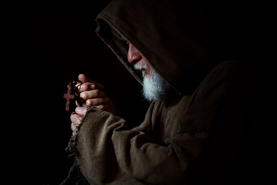 Medieval monk with rosary in prayer