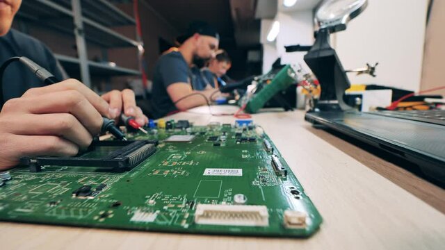 Circuits of a laptop are getting soldered by a repairman