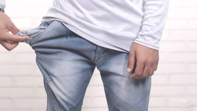 young man shows empty pant pocket with copy space 