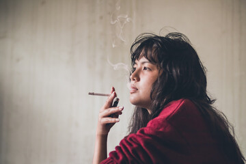 Obraz premium Stressed woman. A depressed woman smoking of stress Caused by social problems It's a concept about drugs and crime