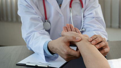 A young man consulted a doctor With a wrist injury in the office at the doctor's desk