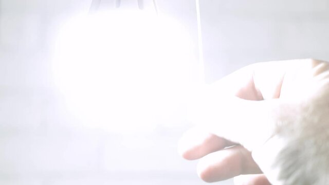 One Person Pull the Switch Cord and Turns On the Light Bulb. Turning On a Led Light in a Room.