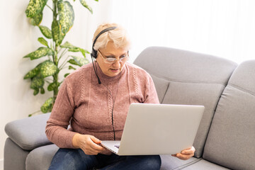 The elderly woman writes on the computer