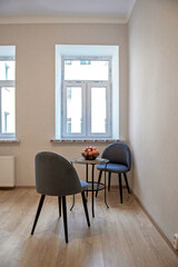 Modern interior design concept. Minimalistic style. Two blue armchairs and a table with fruit.