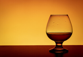 Snifter glass on an orange background