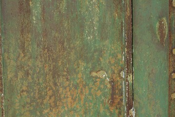 green metal  texture from an old iron wall with a brown rusty seam