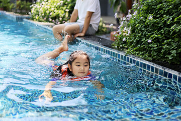 Asia children relaxation and playing in the water In the hotel pool during the holidays.