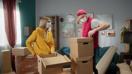 Customer paying to delivery man using NFC technology with phone and credit card, contactless terminal payment with student girl to professional mover. Cell phone. New flat or office. Daylight - Powered by Adobe