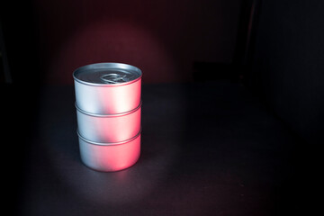 Closed cans with a dark background and colored lights. Danger of canned food and the health effects...