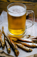 Beer in a glass beer mug and smoked fish