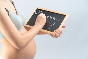 close up Asian pregnant woman use the small blackboard for thinking her name of her is infant