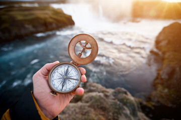Beautiful landscape with old compass on traveler's hand. Traveling concept. © Lukas Gojda