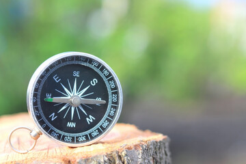Classic navigation compass on natural background as symbol of tourism with compass, travel with...