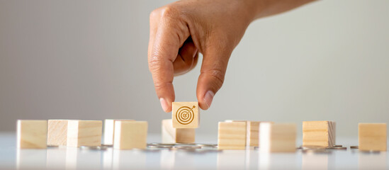 Business man hand close up select goal and target icon on wooden block target concept business success.